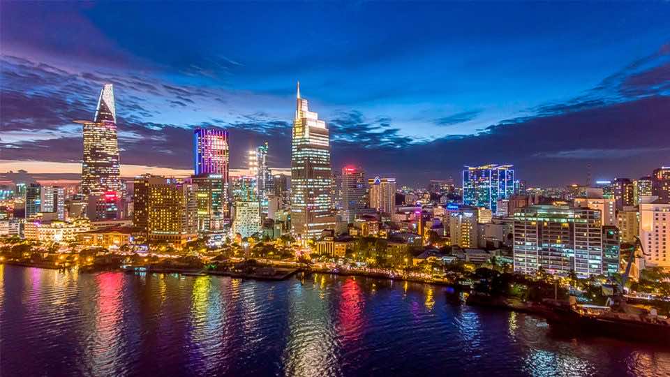 5 Top Lady Bars In Saigon, Vietnam (2026 Guide) 1 Aerial view of Saigon's District 1 at night with lights reflecting off the Saigon River